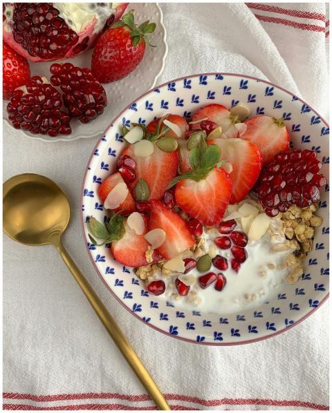 A vibrant breakfast bowl with strawberries, pomegr