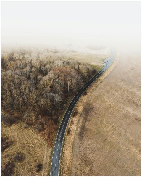 A misty aerial scene showing a winding road throug