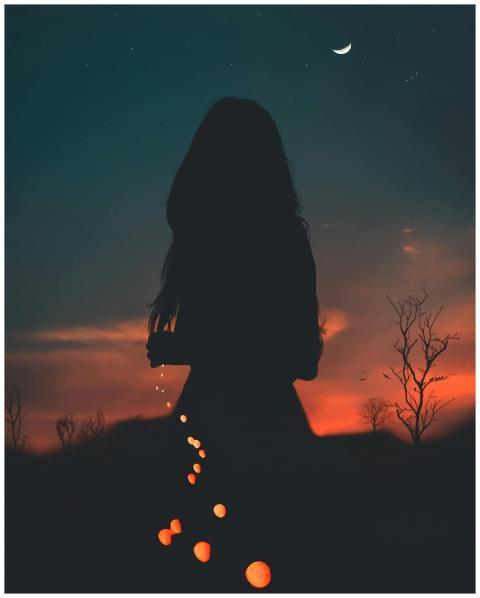 A silhouette of a person at twilight under a cresc