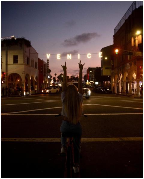 A woman with arms raised enjoys a vibrant evening