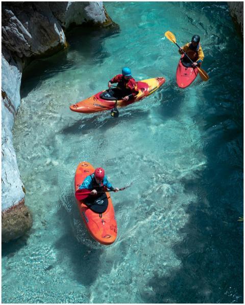Three kayakers paddle through the stunning clear w