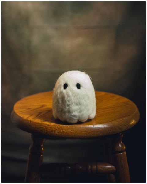 Charming wool ghost figurine sitting on a vintage