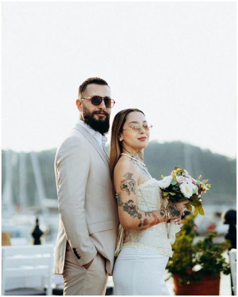 A fashionable couple posing elegantly by a marina,