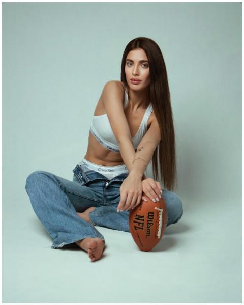Casual portrait of a young woman in jeans holding