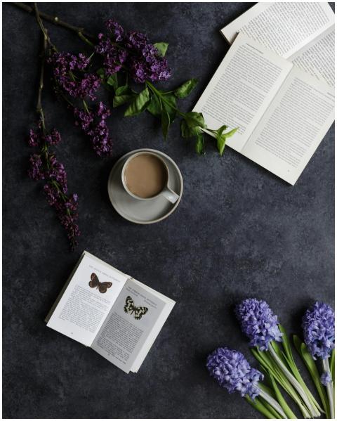 Top view of cup of coffee near bright flowers and
