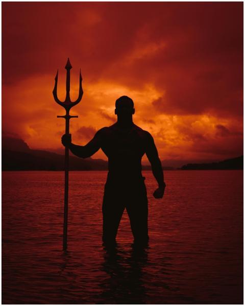 Powerful silhouette of a cosplayer holding a tride