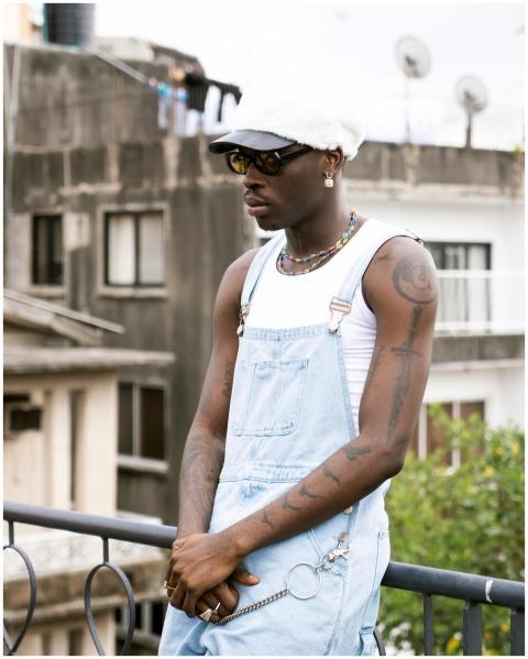 Stylish urban portrait of a young man in denim ove