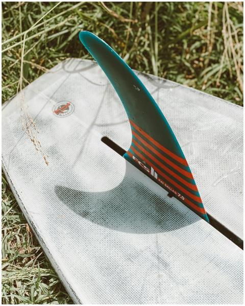 Detail of surfboard fin on grass in Hawaii, emphas