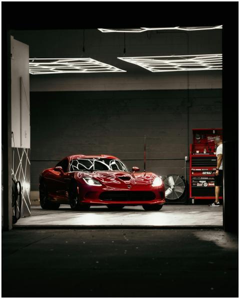 Red sports car in a garage workshop at night, show