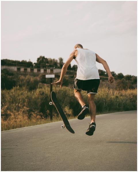 A skateboarder performs a trick on a sunny day in