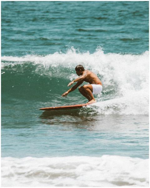 Man surfing on ocean wave, showcasing thrilling wa