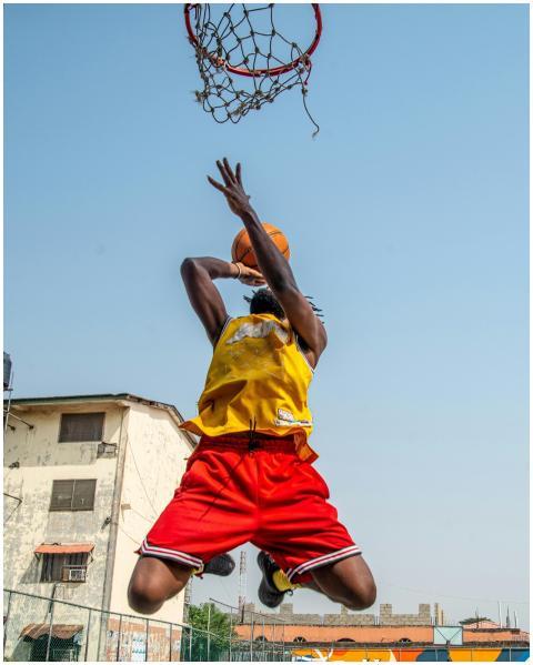 An athlete in midair performs a basketball dunk ou