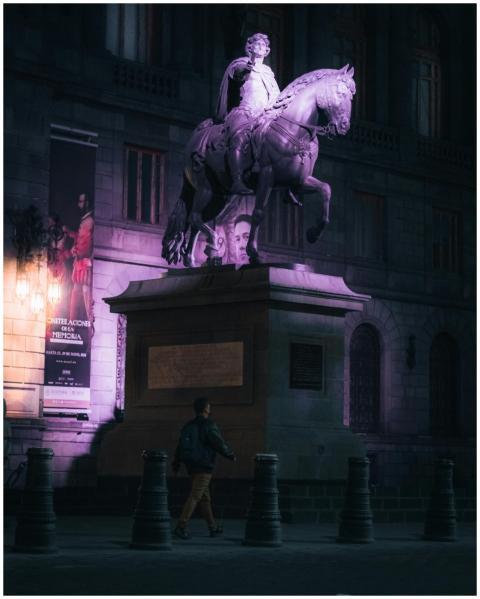 A nighttime view of an equestrian statue in Mexico