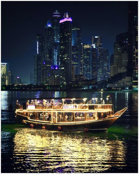 A traditional dhow boat illuminated against the st