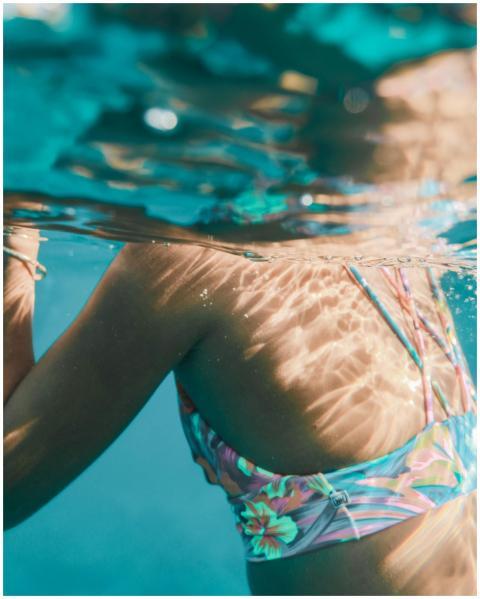 Close-up of a woman swimming underwater in a color