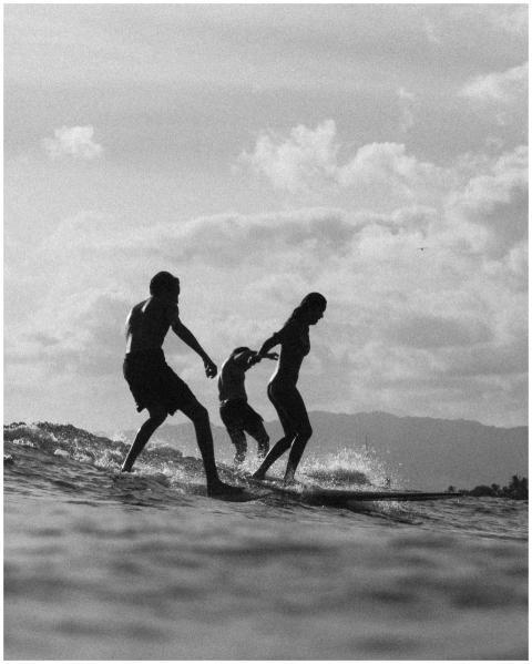 Silhouette of a family enjoying surfing in Hawaii,