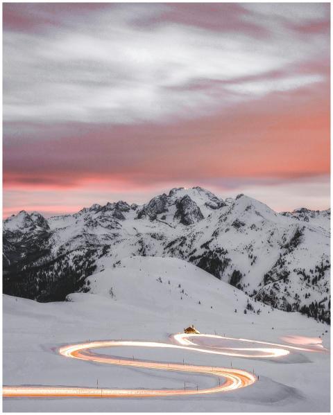 A winding road glowing under sunset skies amidst t