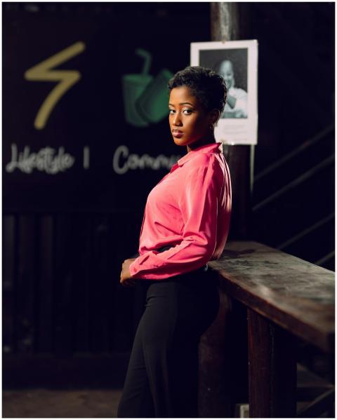 Confident woman posing in stylish pink shirt in a