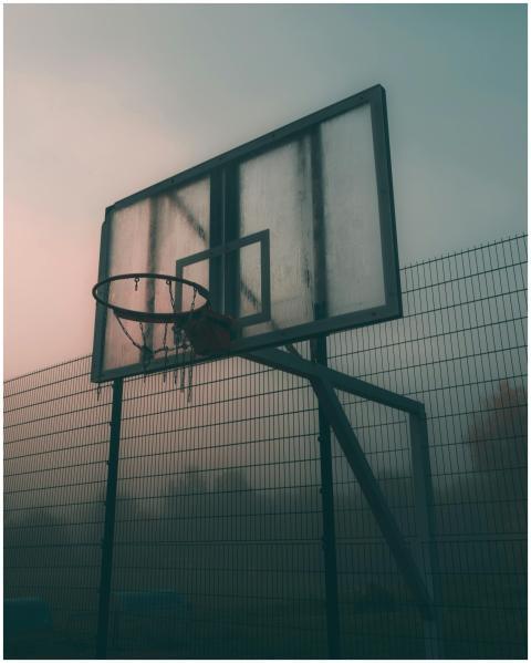 Moody shot of a basketball hoop on a foggy morning