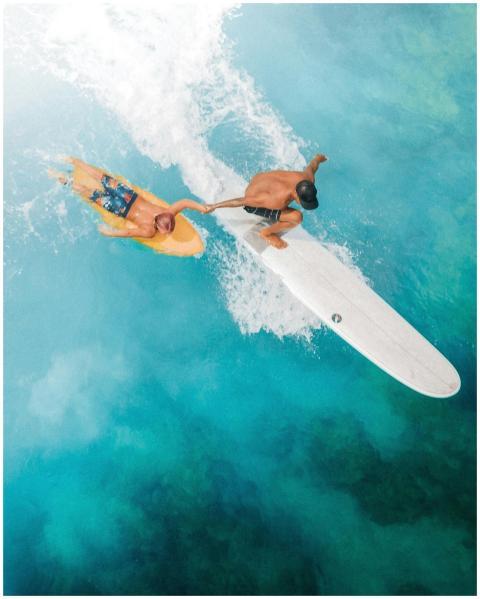 A vibrant aerial shot of two surfers riding waves