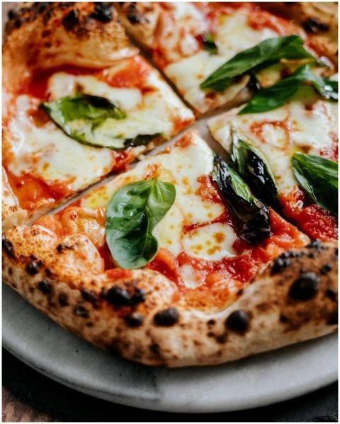 Close-up of a Neapolitan pizza with fresh basil le