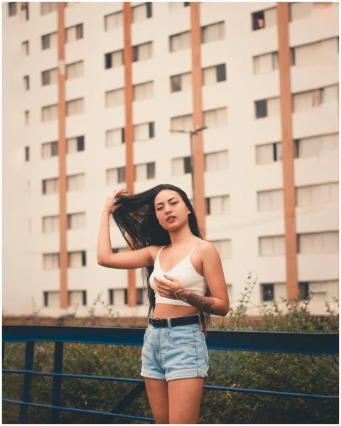 Stylish woman wearing denim shorts and a crop top,