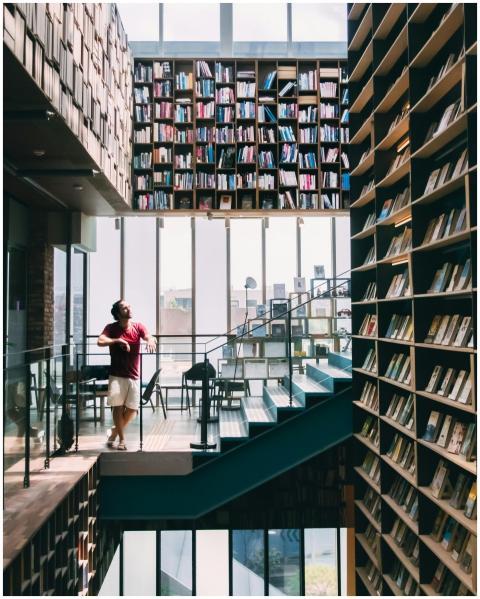 Spacious library with towering bookshelves and a p