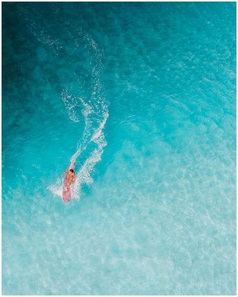 Captivating aerial shot of a surfer riding clear b