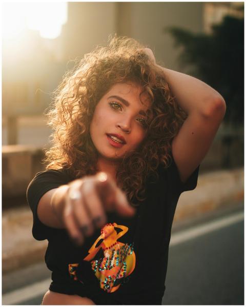 Portrait of a fashionable woman with curly hair po