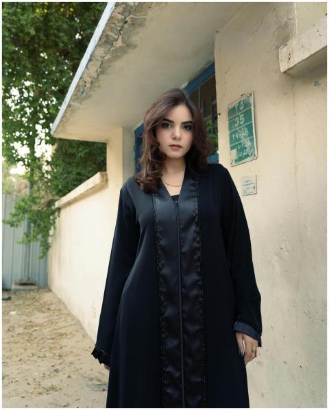 Elegant woman in traditional black abaya, posing o