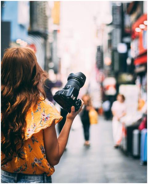 Woman with camera walks through vibrant Seoul stre