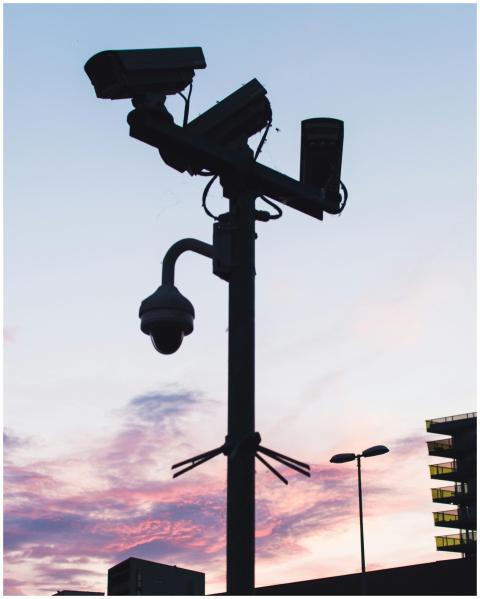 Silhouette of surveillance cameras and streetlight