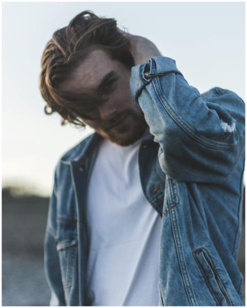 Portrait of a stylish young man adjusting his hair