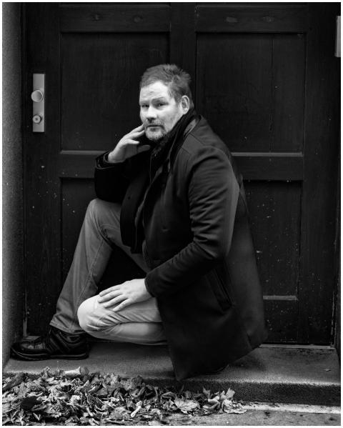 Black and white portrait of a man sitting thoughtf