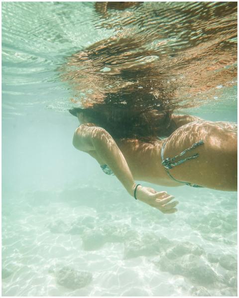 Woman snorkeling beneath clear ocean waters in Hon