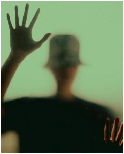 Blurred silhouette of a person with raised hand ag