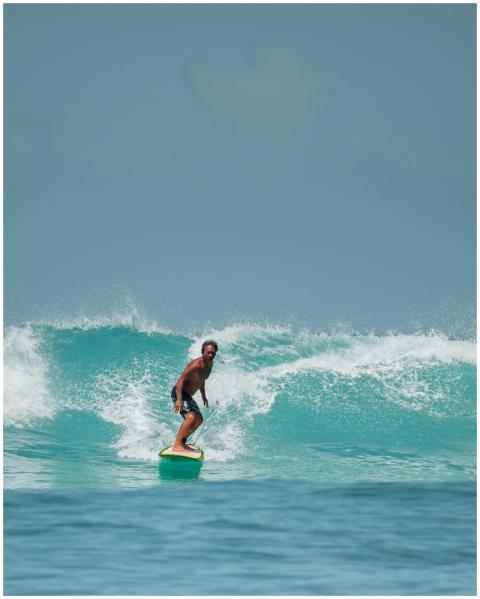 A surfer skillfully rides a powerful wave in Honol