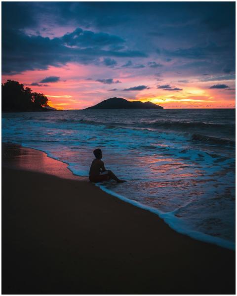 Tranquil beach scene during sunset featuring a sol