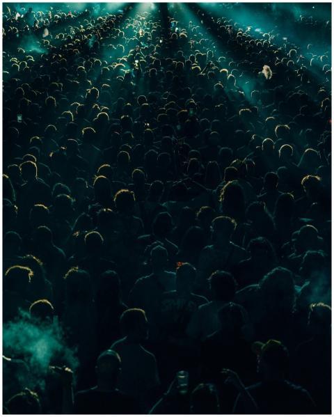 A dense crowd enjoys a lively concert at night wit