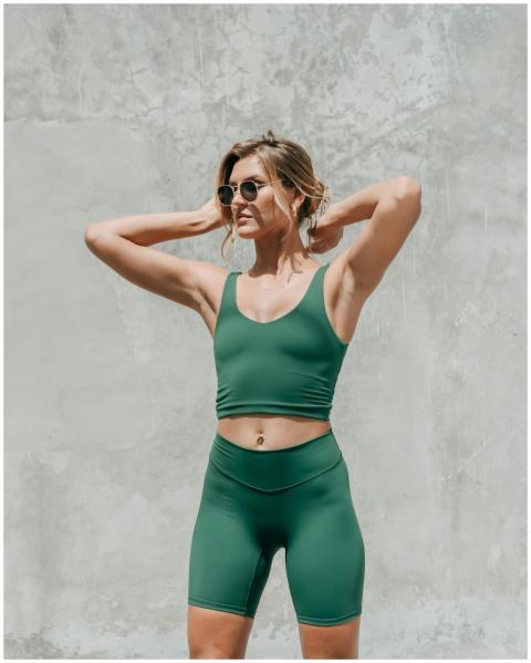 Stylish woman in green workout attire posing again