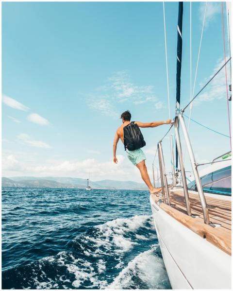 Man sailing in vibrant Greek waters, depicting fre