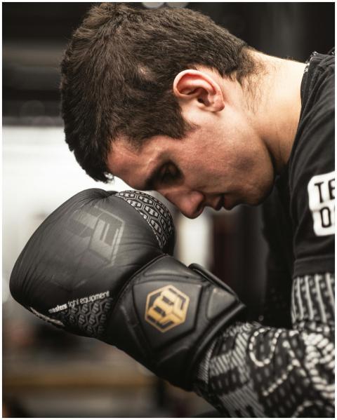 A determined boxer with gloves, preparing for an i
