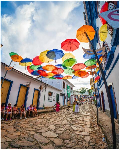 Vibrant umbrellas adorn a historic street in Tirad