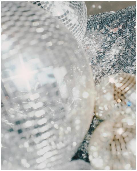 Close-up of shiny disco balls on a sequin surface,