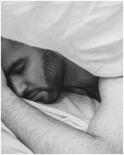 A serene black and white image of a young man slee