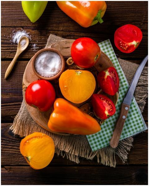 Colorful tomatoes and peppers on a rustic wooden t