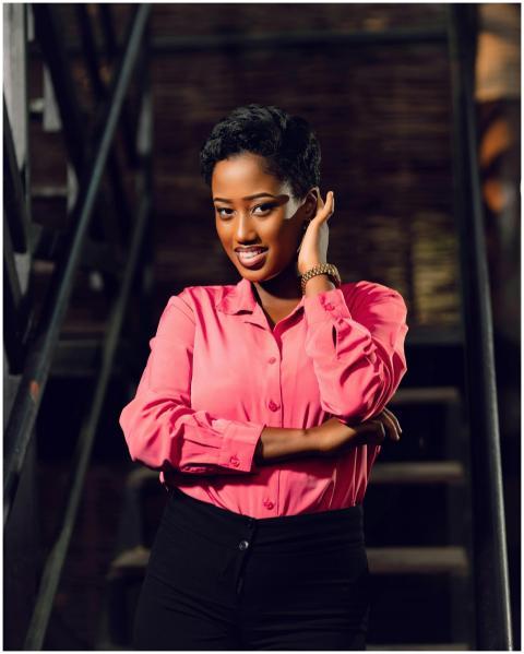 Confident woman in a pink shirt posing on a stairc