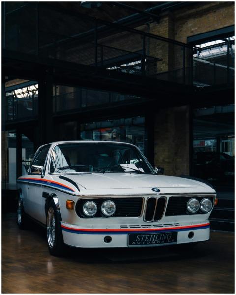 A vintage BMW car showcased in an industrial indoo
