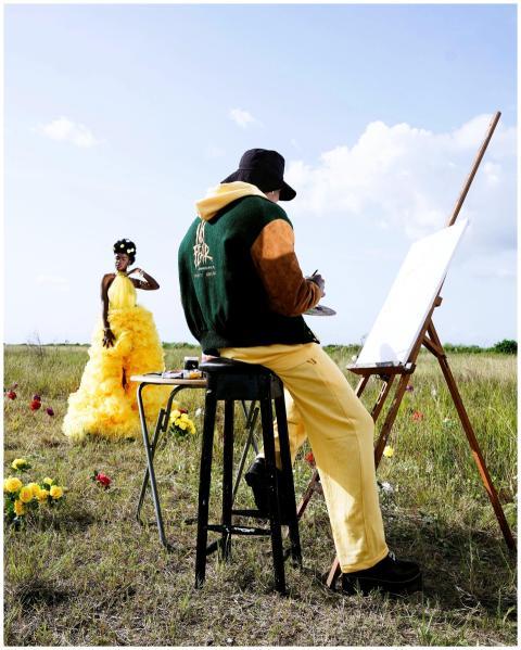 Artist painting a model in a yellow dress outdoors