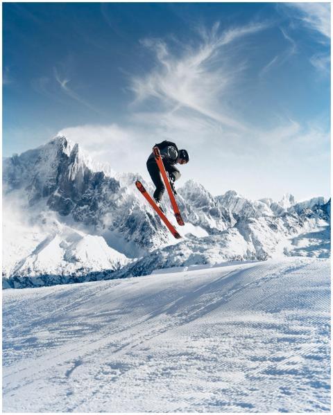 Dynamic ski jump in stunning snowy mountain landsc